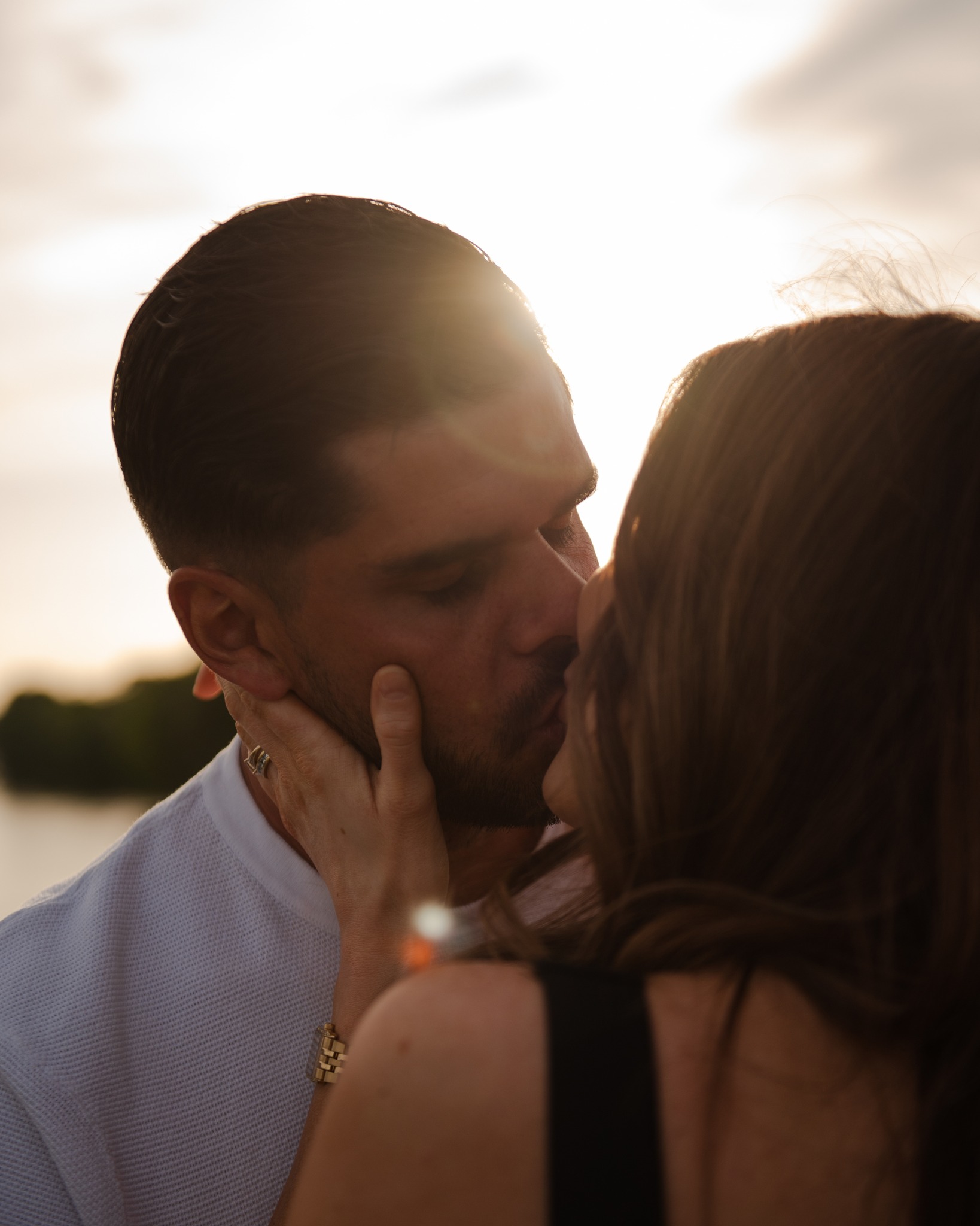 Contre-jour saisissant, lumière qui explose derrière eux, un baiser enveloppé d'or. 

La magie de la photographie réside