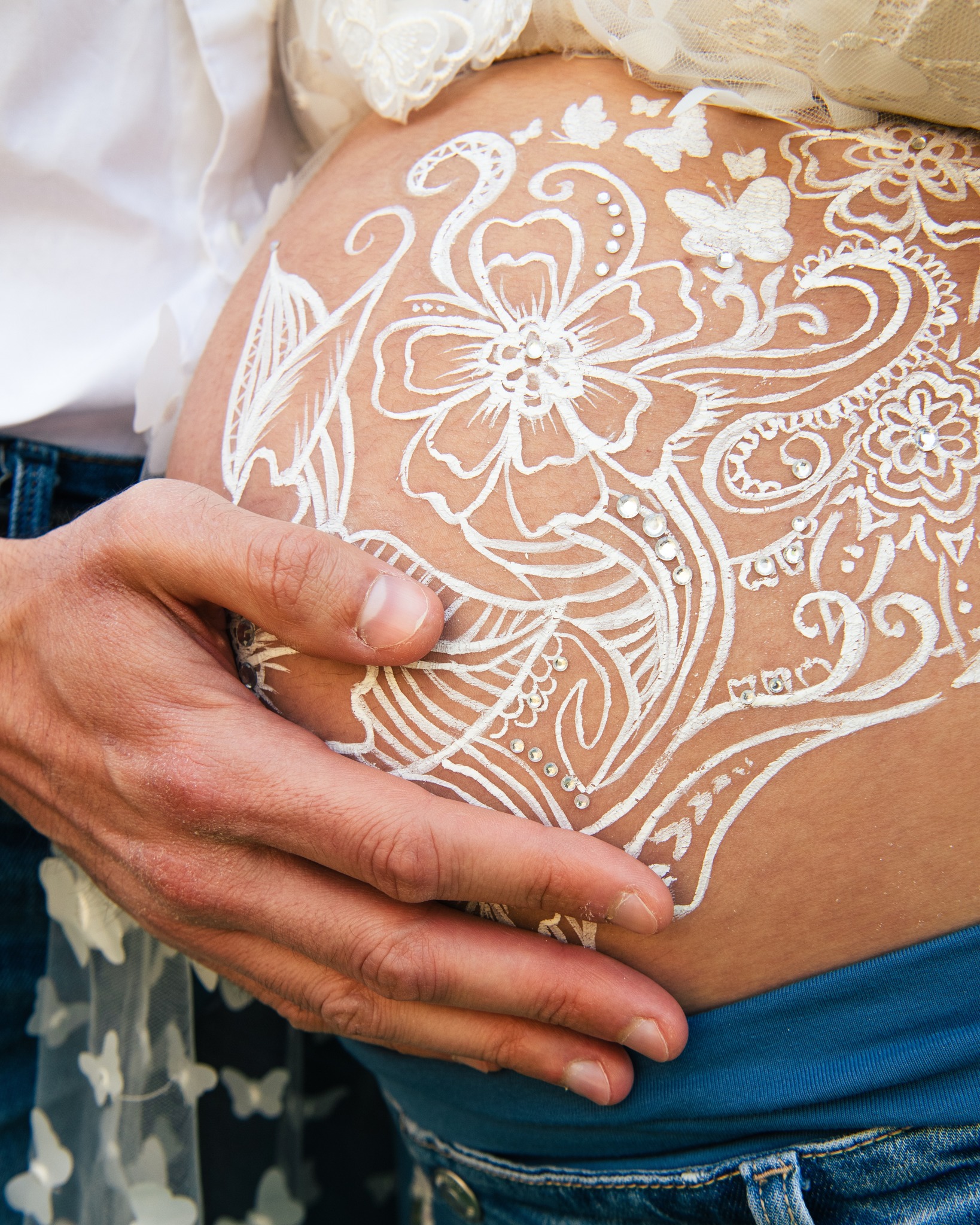 Un ventre orné de motifs délicats, une main posée avec amour, l'art du belly painting sublimé par la photographie. 

Cha
