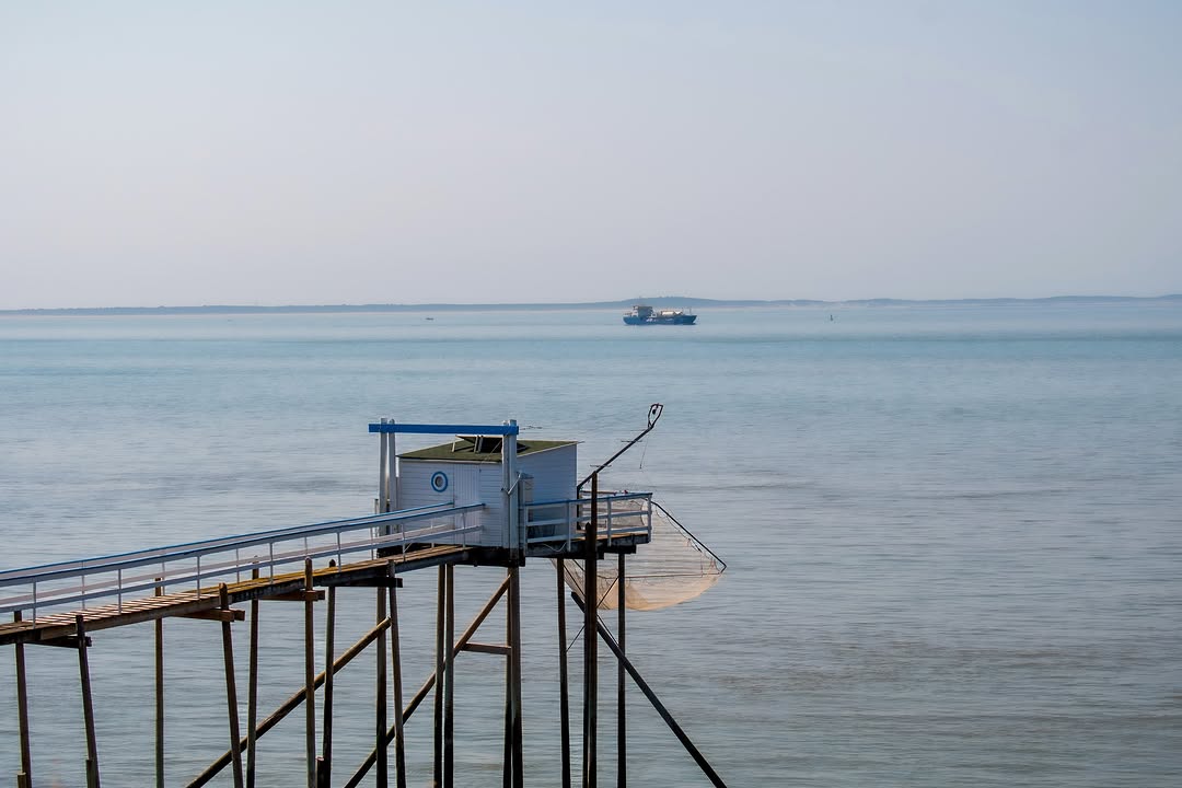 Là où le silence prend la mer ~ 🌊 

Un bateau traverse l’horizon, lentement. 

Face au large, le carrelet reste immobil